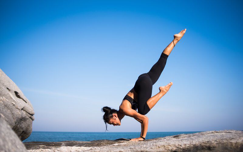 woman doing yoga on rock