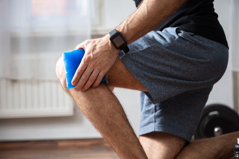 man holding ice to knee for pain